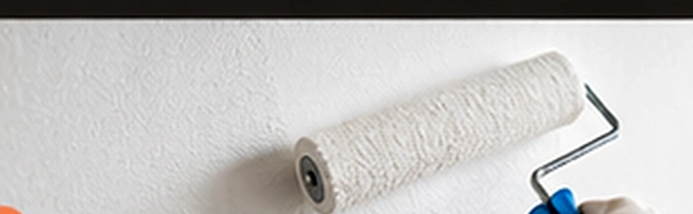 Peintre appliquant une peinture blanche au rouleau sur un mur